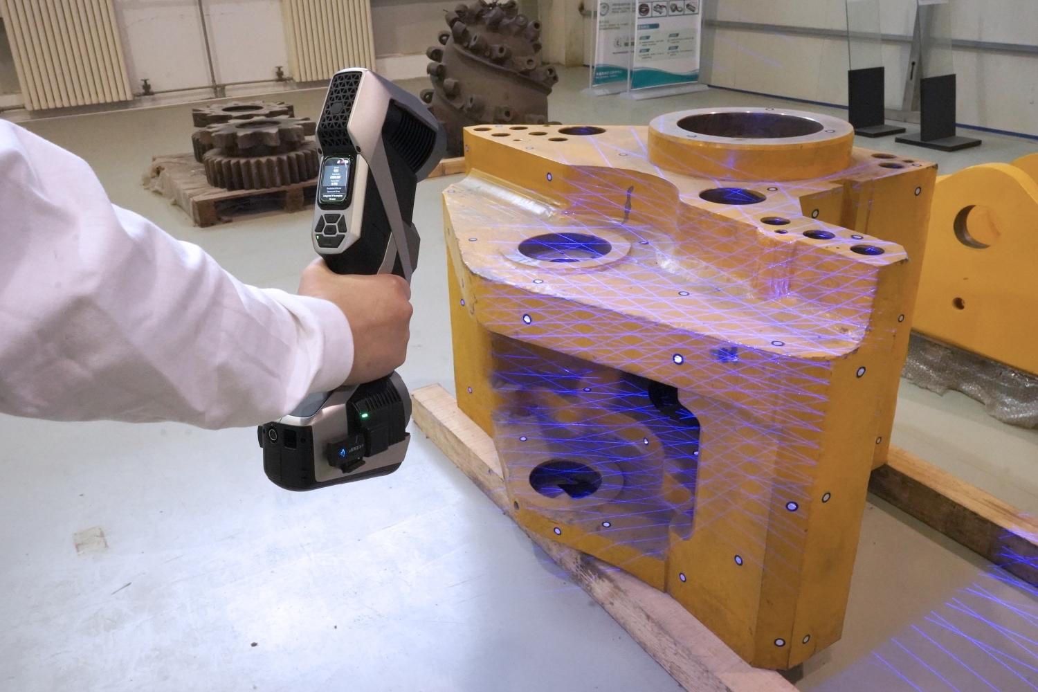 Engineer holding a scanner to a large part