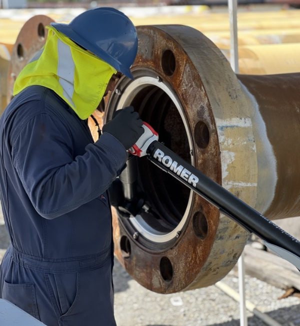Technician using a ROMER portable arm for inspection on a large industrial flange.